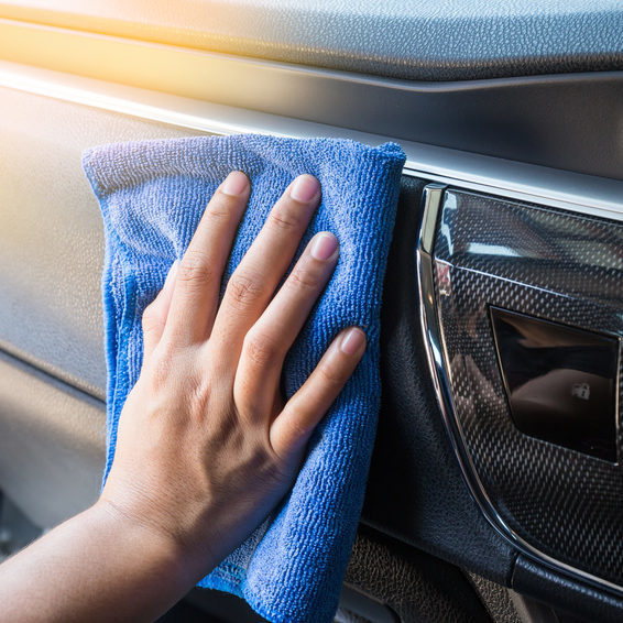 Hand with microfiber cloth cleaning Interior modern car.